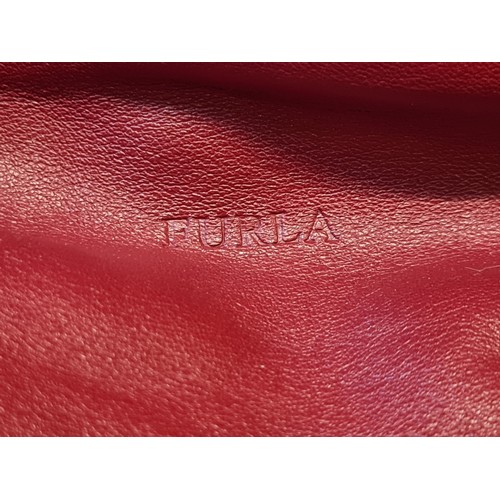 78 - A striking genuine leather ladies handbag by designer brand Furla. An elegant example in a ruby red ... 