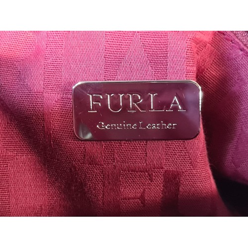 78 - A striking genuine leather ladies handbag by designer brand Furla. An elegant example in a ruby red ... 