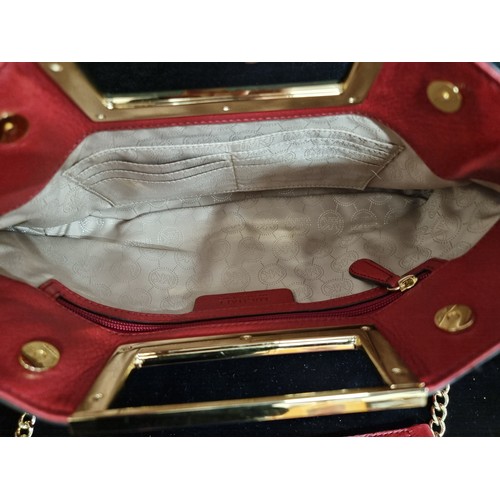 63 - Star Lot : A very stylish red leather clutch by Michael Kors featuring rectangular hardware handle, ... 