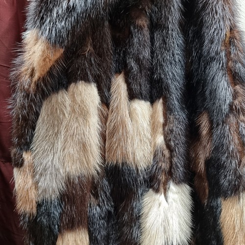 132 - Star Lot : A very elegant women's genuine fur coat. Features a patchwork of furs in tones of camel, ... 