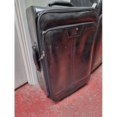 216 - A suite of three black soft leather suitcases and travel bags by Mont Blanc. Includes a large (47 x ... 