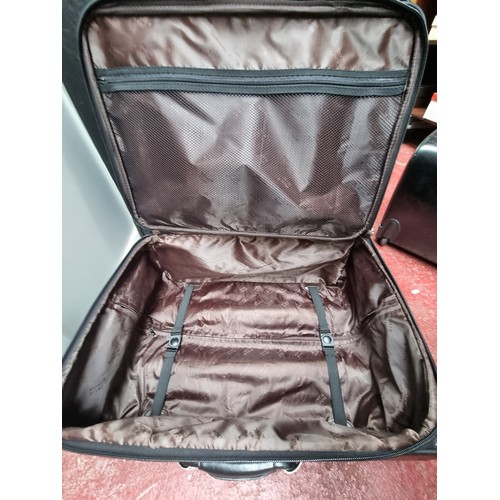 216 - A suite of three black soft leather suitcases and travel bags by Mont Blanc. Includes a large (47 x ... 