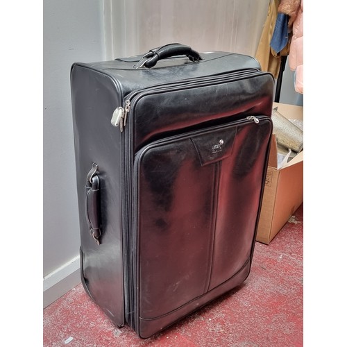 216 - A suite of three black soft leather suitcases and travel bags by Mont Blanc. Includes a large (47 x ... 