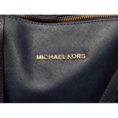 225 - A stylish ladies handbag by designer brand Michael Kors. Designed in a rich navy blue with branded h... 