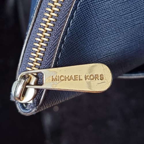 225 - A stylish ladies handbag by designer brand Michael Kors. Designed in a rich navy blue with branded h... 