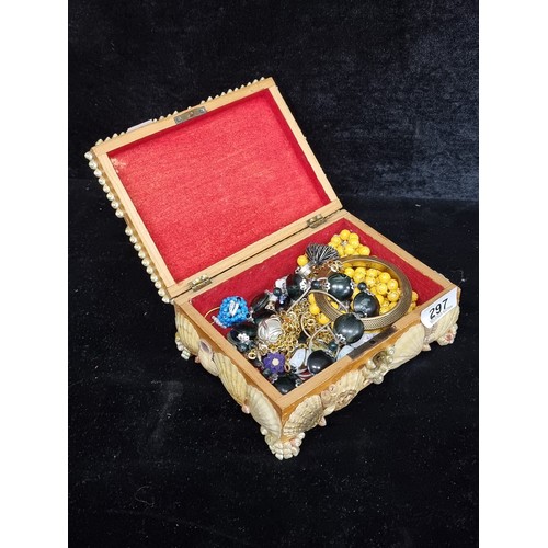 297 - A quantity of unchecked costume jewelry housed in a handmade wooden box covered in shells. .