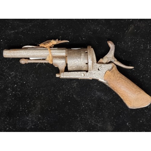 324 - An antique flintlock revolver with wooden grip and metal body featuring foliate etched design.