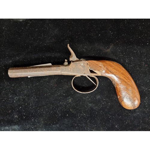 325 - An antique percussion pocket pistol with wooden grip and cast iron barrel.