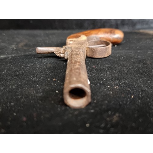 325 - An antique percussion pocket pistol with wooden grip and cast iron barrel.