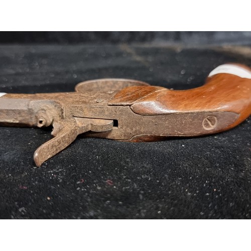 325 - An antique percussion pocket pistol with wooden grip and cast iron barrel.