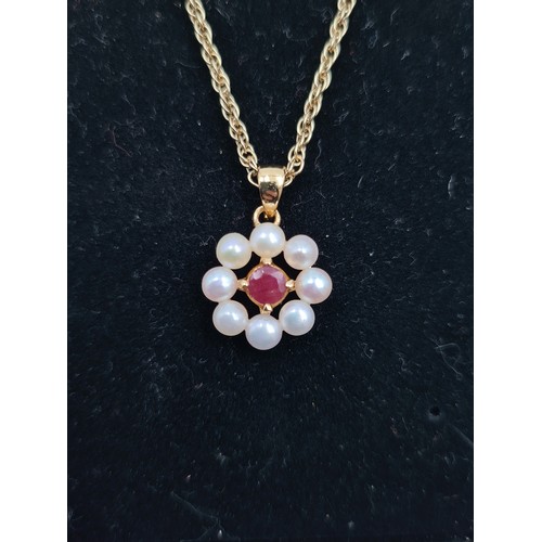 237 - A circular Pearl pendant necklace, with a striking Ruby stone accent. A pretty example with an adjus... 