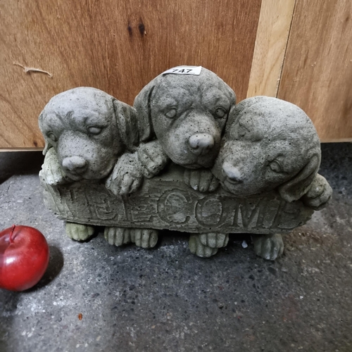 747 - A charming reconstituted stone garden ornament in the form of three life-size puppies. With the text... 