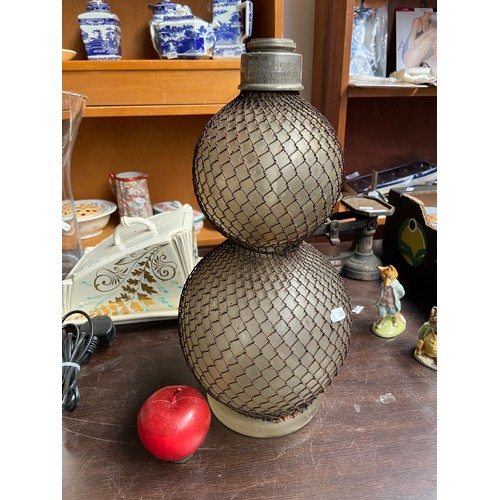 762 - An antique handblown glass syphone with cord net surrounding the globular base and branded The Briti... 