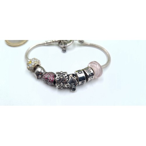 63 - A sterling silver Chamilia designed charm bracelet, featuring an array of pretty gem stone charms in... 