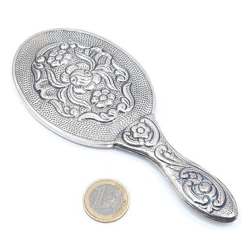 67 - A fine example of a Sterling Silver hand mirror, featuring attractive embossed floral motif to rever... 