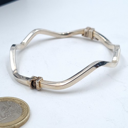 69 - A sterling silver sleek design twist bracelet, set with a double safety clasp. Weight: 6.8 grams. Di... 