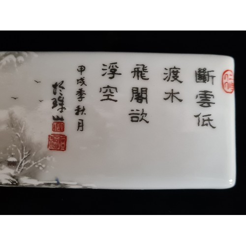 122 - A porcelain Chinese rectangular scroll weight featuring a peaceful forest winter scene and Chinese t... 