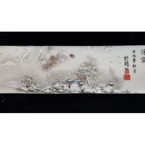 122 - A porcelain Chinese rectangular scroll weight featuring a peaceful forest winter scene and Chinese t... 