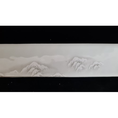 122 - A porcelain Chinese rectangular scroll weight featuring a peaceful forest winter scene and Chinese t... 