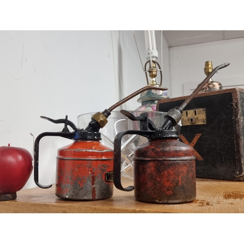 190 - A great pair of vintage metal oil cans with one example by Wesco in classic shades of red.