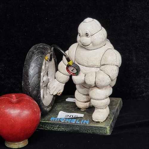 208 - A remarkably heavy cast metal figure of the iconic Michelin Man pumping up a tyre.