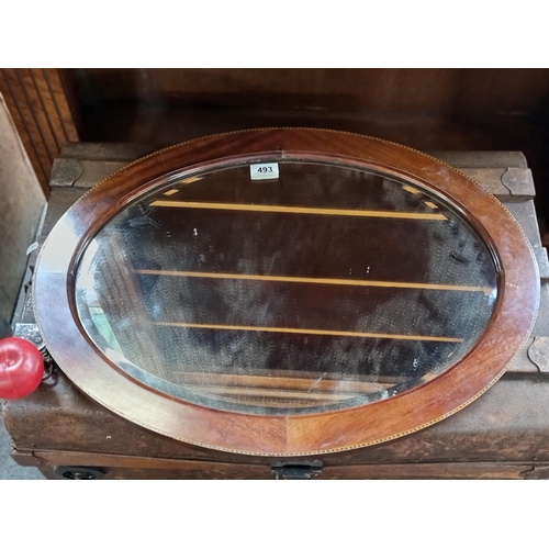 493 - A very attractive example of an antique oval wall mirror. The beveled mirror is sent into a heavy qu... 