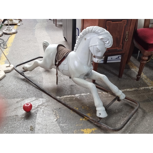 495 - A vintage white rocking horse mounted on a metal frame base with original fabric saddle. A lovely no... 