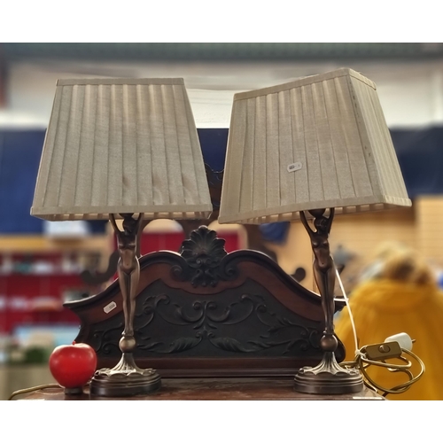 498 - A pair of bronzed Art Deco style figural lamps in the form of stretching women. With lovely scallope... 