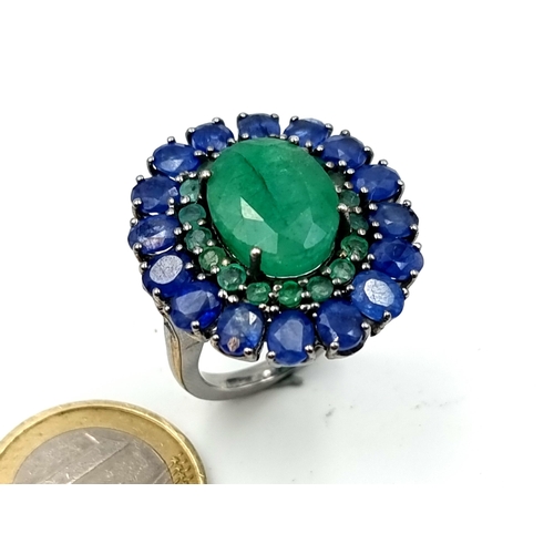 653 - Star Lot : A  new fabulous large emerald stone set ring with emerald and sapphire surround mounted i... 