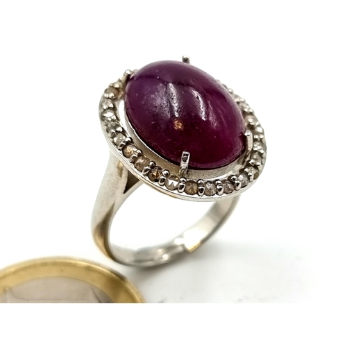 654 - Star Lot : An attractive ruby set stone ring with diamond halo setting, mounted in sterling silver. ... 