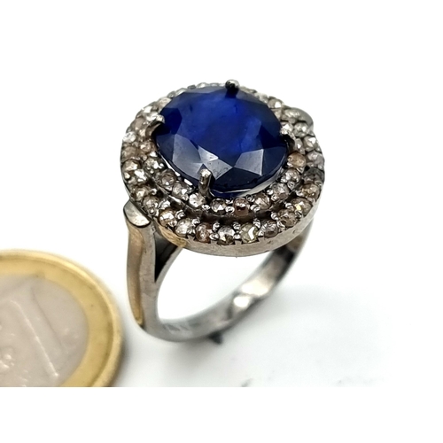 656 - Star lot : A blue sapphire ring of 7 carats with a halo of 1.25 diamond accents. Size P. Brand new f... 