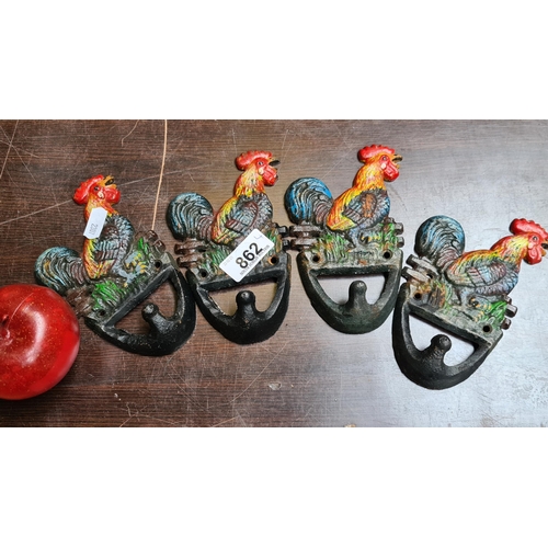 862 - Four vibrant cast metal wall hangers with a hook and rooster finial each.