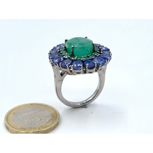 653 - Star Lot : A  new fabulous large emerald stone set ring with emerald and sapphire surround mounted i... 