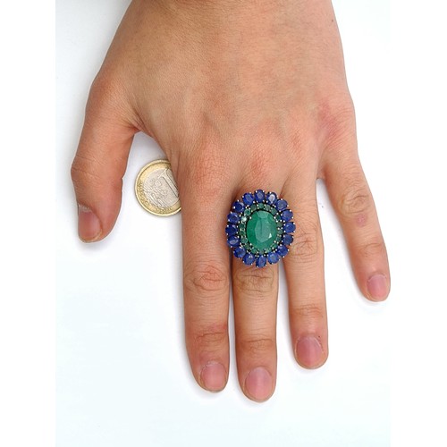 653 - Star Lot : A  new fabulous large emerald stone set ring with emerald and sapphire surround mounted i... 