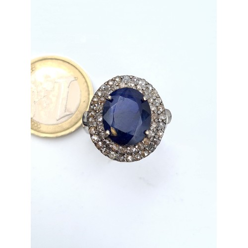 656 - Star lot : A blue sapphire ring of 7 carats with a halo of 1.25 diamond accents. Size P. Brand new f... 