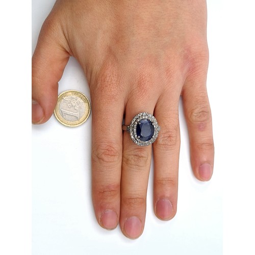 656 - Star lot : A blue sapphire ring of 7 carats with a halo of 1.25 diamond accents. Size P. Brand new f... 