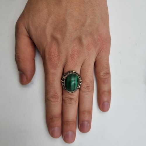 880 - An antique silver malachite cabochon stone ring with raised detailing. Size O.
Weight: 10.11 grams