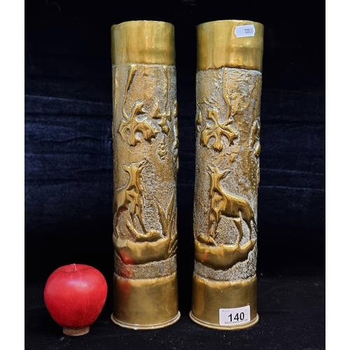 140 - A pair of hammered brass trench art military shells. These large examples feature repoussé work deta... 