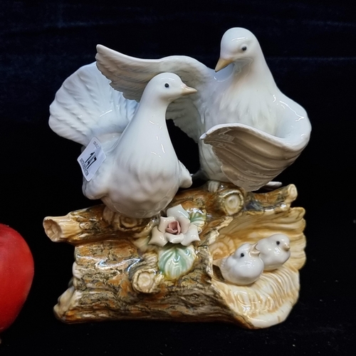 147 - A beautiful porcelain sculpture of a pair of turtle doves with two tiny chicks. Depicted perched on ... 