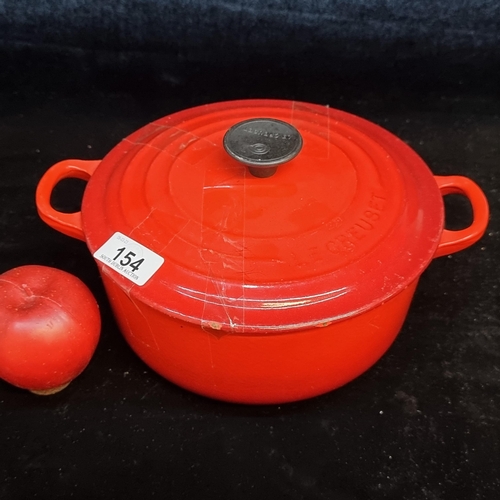 154 - A heavy cast iron Le Creuset casserole pot. Designed in a graduating red enamel with a heat resistan... 