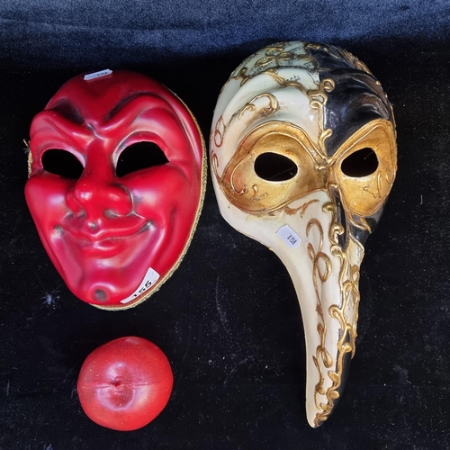 155 - Two charming Venetian masks. Including a grinning devil in red and a black and gilt plague doctor st... 