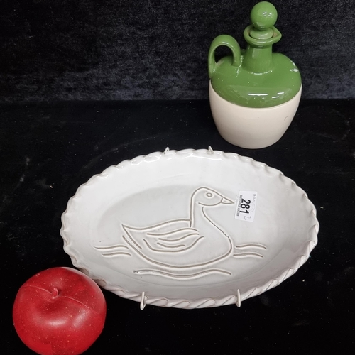 Two charming ceramic items including a terracotta cabinet plate depicting a stylised goose on water. Along with a whiskey jug illustrated with pheasants and with original stopper.