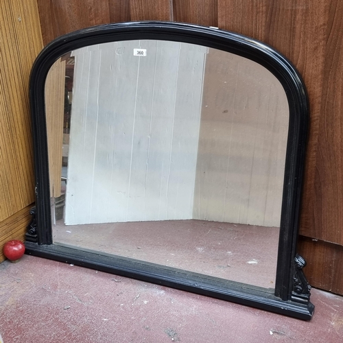 360 - A brilliant over mantle mirror with beveled glass and house in a black wooden frame. In very good co... 