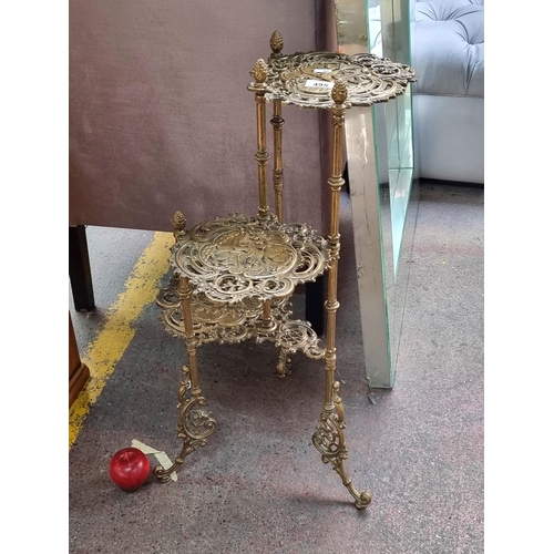 A gorgeous three-tier brass plant stand. A very ornate piece boasting a  pattern of song birds in hig