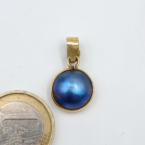 516 - An attractive double sided 9 carat gold pendant, set with a pretty lustre freshwater Pearl. Total we... 