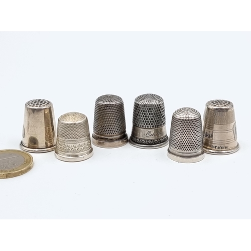 524 - A collection of six sterling silver thimbles. Of particular interest, a Thimble by the notable maker... 