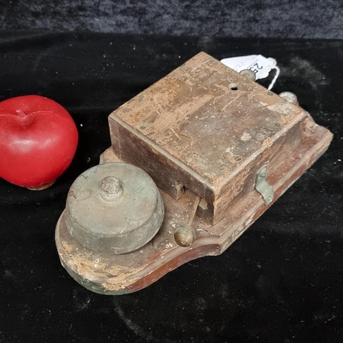 251 - A great early 1900s electric door bell. Featuring a brass bell and mallet mounted on a wooden base.