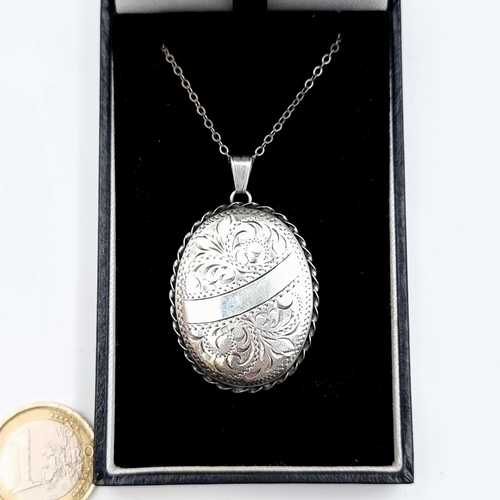 52 - A large sterling silver pendant locket and chain, featuring a lovely floral and folaite motif. Dimen... 