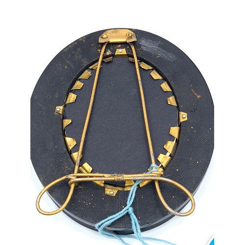 536 - A miniature portrait painting of a handsome gentleman in period dress. Housed in a oval black and gi... 