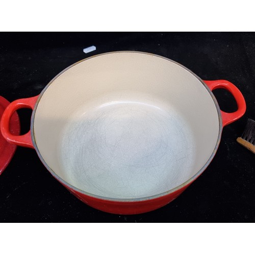 154 - A heavy cast iron Le Creuset casserole pot. Designed in a graduating red enamel with a heat resistan... 